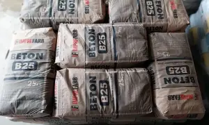 Sztaple worków z betonem B25, każdy po 25 kg. Zastanawiasz się, ile cementu na 1m3 betonu? Te worki to gotowa sucha mieszanka.