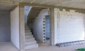 Wnętrze budowy z betonowymi schodami i otwartym przejściem. Jaki otwór pod drzwi 80 cm będzie idealny do tego pomieszczenia.