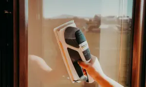 Ręka trzymająca odkurzacz do okien Karcher, pokazująca, jak myć okna.