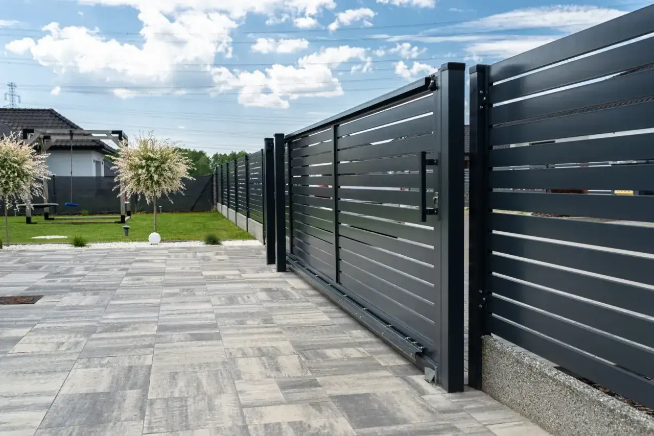 Solidny fundament pod bramę przesuwną zapewnia jej stabilność i płynne działanie. Nowoczesna brama wjazdowa z betonowym podmurzem.