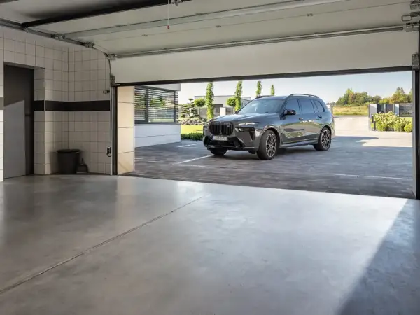 Nowoczesna posadzka w garażu, na której stoi luksusowy SUV.