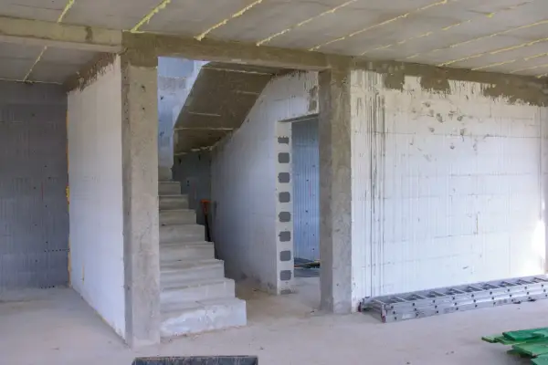 Wnętrze budowy z betonowymi schodami i otwartym przejściem. Jaki otwór pod drzwi 80 cm będzie idealny do tego pomieszczenia.